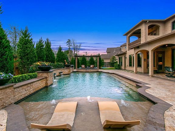 Custom pool complete with tanning ledge, fountains, fire pits, flower pots with irrigation and a raised spa!