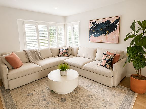 Spacious living room that is light and open facing a fireplace and TV