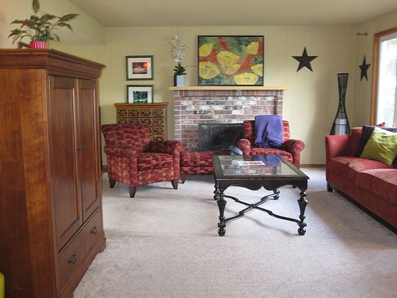 Large living room with wood burning fire place and big windo