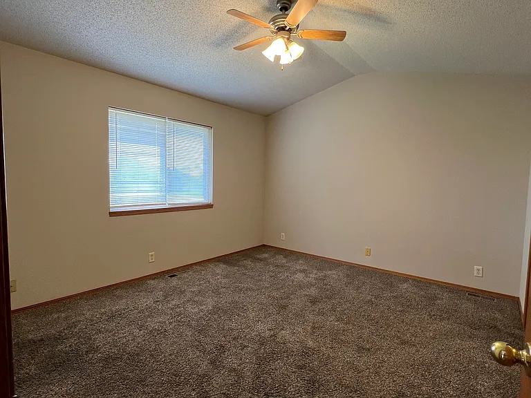 Main floor master with vaulted ceiling, ceiling fan, walk-in closet and private bathroom