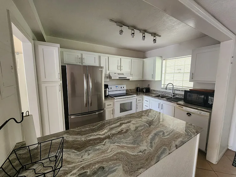 Renovated kitchen, with granite and new fridge. Plenty of space for storage. Kitchen has everything one needs to prepare food.
