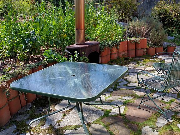Backyard patio with wood stove and large gardening space