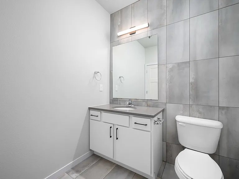 Modern bathroom with sleek grey tiles, a stylish vanity, and contemporary lighting. Modern bathroom with sleek grey tiles, a stylish vanity, and contemporary lighting.