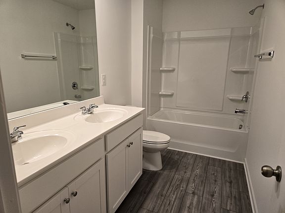 Shared bathroom - two sinks, toilet, shower tub.