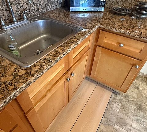 new laminate flooring being installed in kitchen, entry, hall, and bathroom.