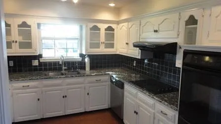Kitchen w/ granite countertop, tumbled marble backsplash