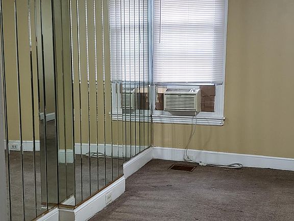 Mirrored dining room with w/w carpet and ceiling fan