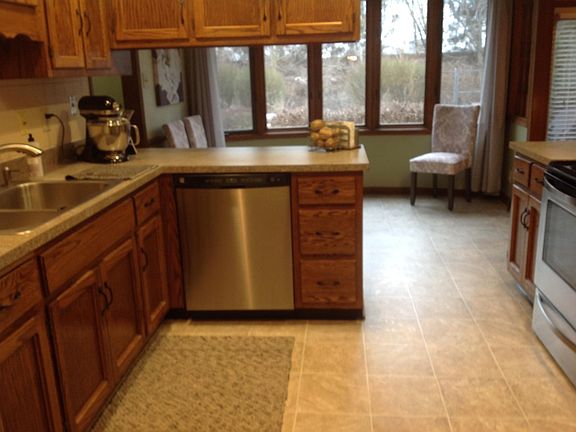 Large kitchen with dinette and all stainless steel appliances (view is from dining room ... laundry/garage/half bath is down hall to left on opposite side of counter and family room is to left off of dinette)