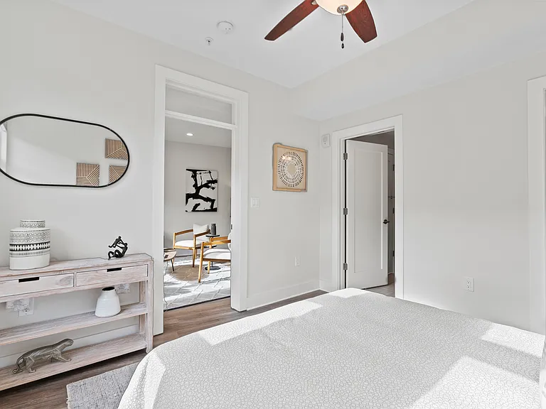 Primary bedroom showing view into living area, bathroom, and walk-in closet