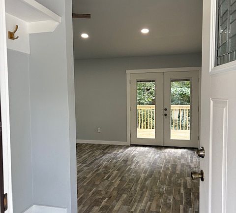 Entry Hall with storage seating bench and built-in coat tree. Beautiful chandelier at entry