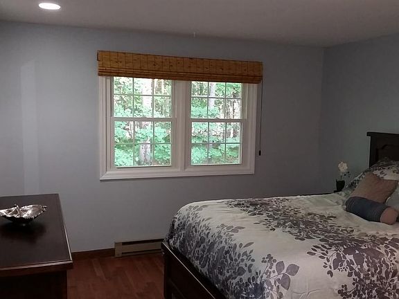 queen size bed with linens and large dresser with mirror & l