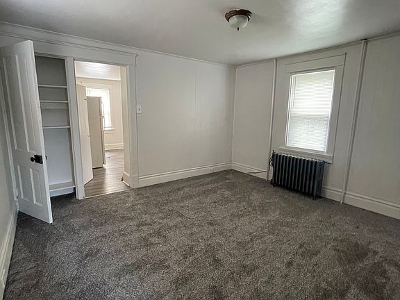 Living room with new carpet and padding, linen/game closet.