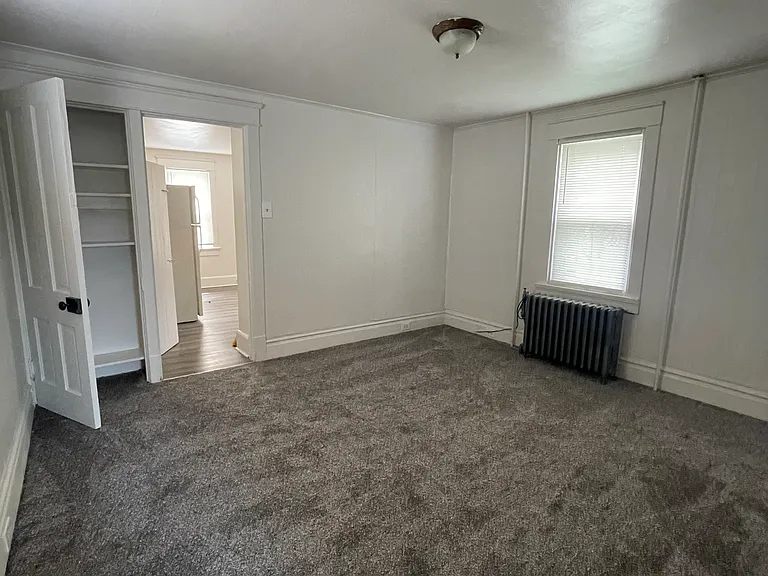 Living room with new carpet and padding, linen/game closet.