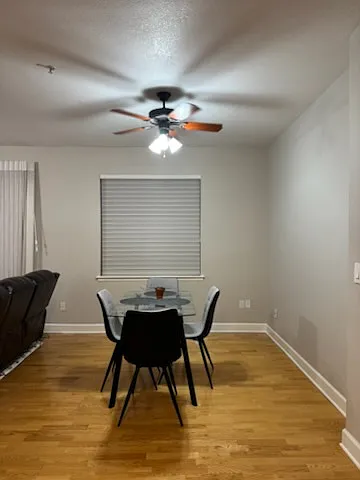 Dining area includes a glass top table and four chairs.