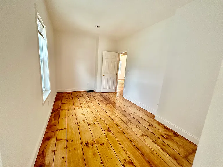 Bedroom- Hardwood floor refinished throughout apartment