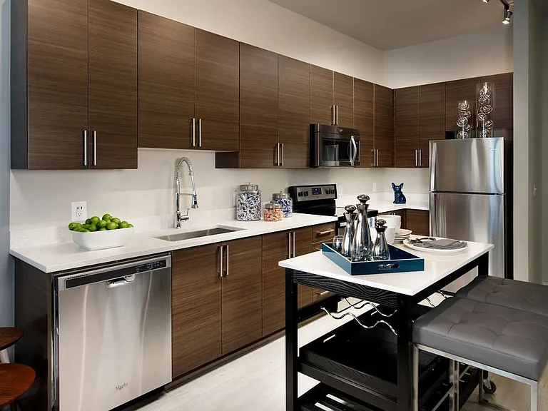 Open concept kitchen with granite countertops, European-style cabinetry, stainless-steel appliances and movable kitchen island