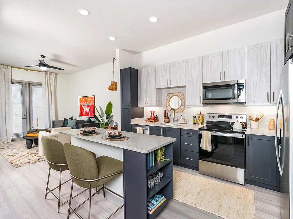 Elevate your culinary skills in our modern kitchen, featuring quartz counter tops, shaker white cabinets with satin pulls, and stainless steel appliances.