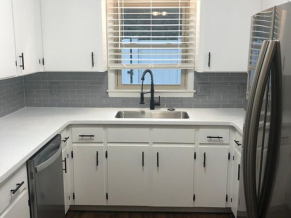 Kitchen with stainless steel appliances, quartz countertop, and deep sink