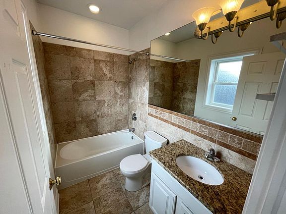 Modern Primary Bathroom with granite throughout.