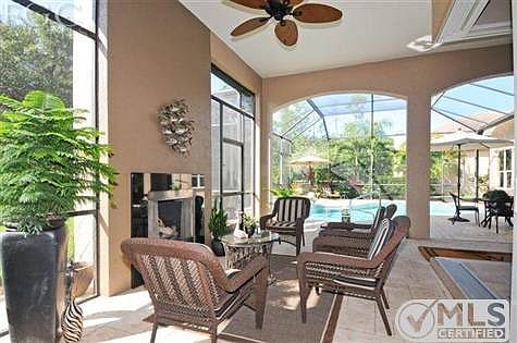 Sitting area on lanai with built in fireplace with granite surroud added around fireplace.  Remote controlled gas logs in fireplace.