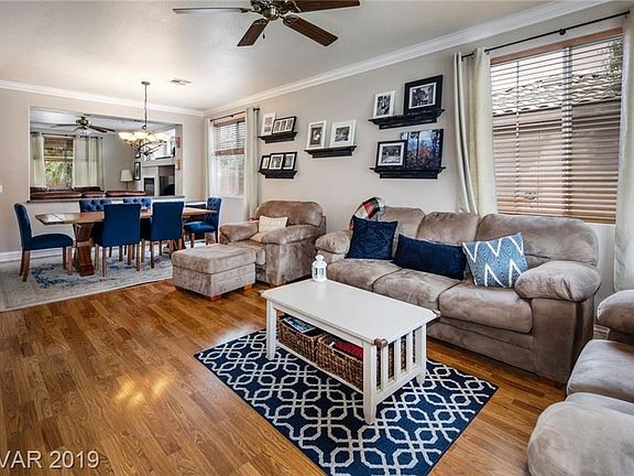 Living room upon entrance looking towards dining area. Note ceiling fans & crown molding.