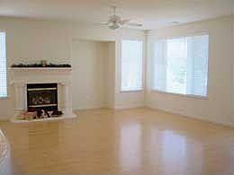 Great Room with Ceiling Fan and Oak Laminate Flooring and Fireplace
