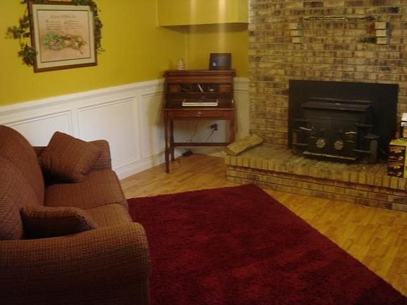 Den with woodstove and waynescoating hard wood and trim new paint