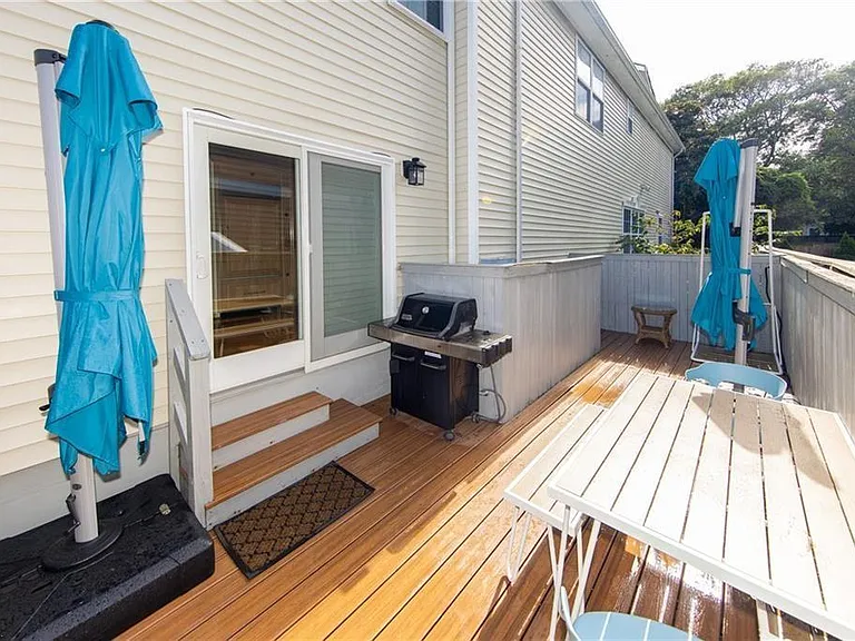 Side patio with table seating for 6 - 8 people, two large 360 degree rotating umbrellas for year-round outdoor dining comfort, natural gas grill (no need to fuss with propane), and turf side yard for cool barefoot walking and playing year round.