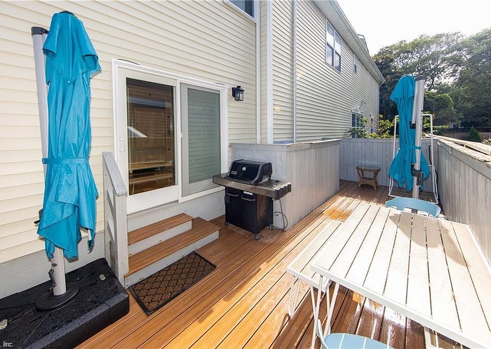 Side patio with table seating for 6 - 8 people, two large 360 degree rotating umbrellas for year-round outdoor dining comfort, natural gas grill (no need to fuss with propane), and turf side yard for cool barefoot walking and playing year round.
