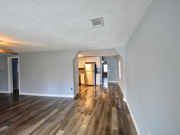 Living room with view to full bath at left and kitchen and bedrooms to right ..