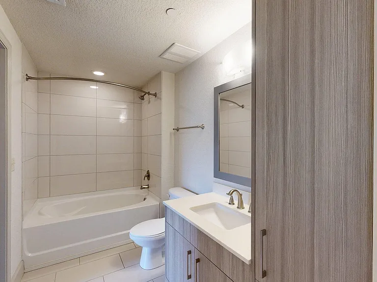 Apartment bathroom with soaking tub and LED lighted mirror.