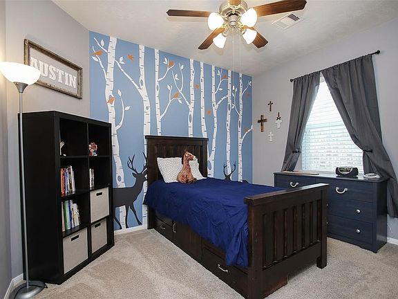 One of the two secondary bedrooms downstairs, the trees are vinyl and can be easily removed leaving a solid blue wall.