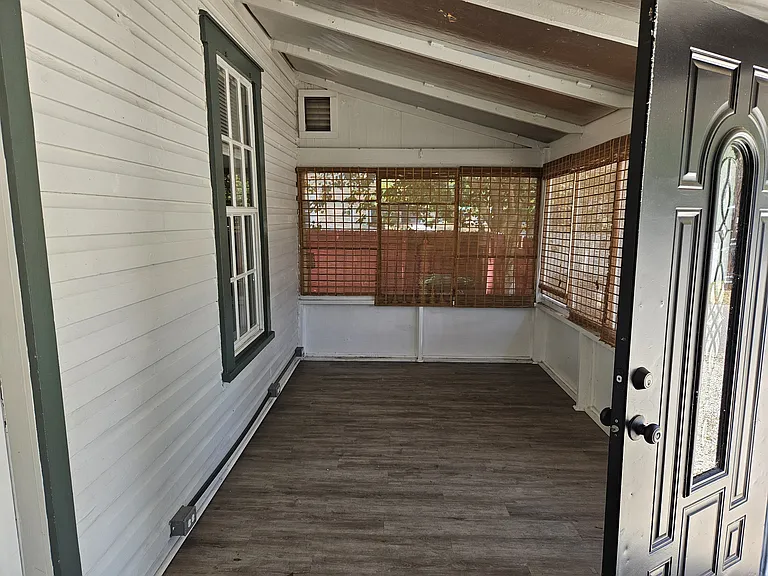 Enclosed front porch with blinds for extra privacy.