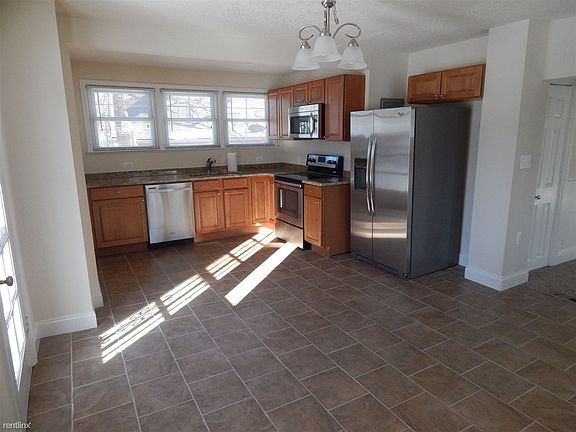 Very large well-lit kitchen with granite counters, stainless