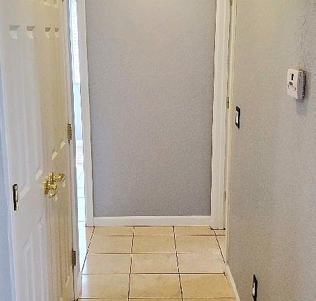 Hallway to bedrooms. Double door pantry on the left. A/C controls on the right.