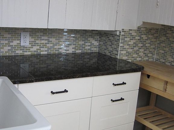 pantry with view of granite countertops, tile backsplash and