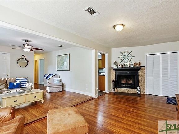 Large living area with woodburning fireplace.  Louvered doors lead to laundry room with enough space for a freezer