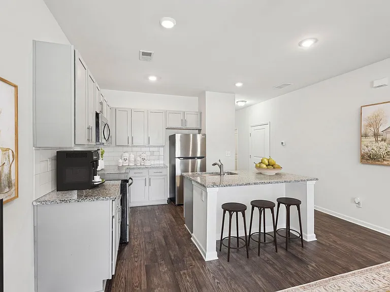 View of the kitchen and entry hallway. Offering bar seating, plenty of cabinet space and granite countertops.