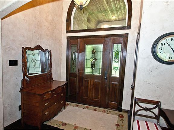 Front Entry with beautiful lead glass door, wood floors and arched window are rustic and inviting