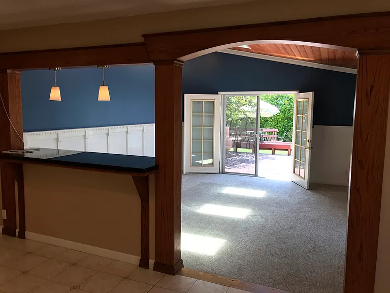 Family room addition with vaulted wood ceiling, skylights, granite countertop, and French doors to redwood deck.