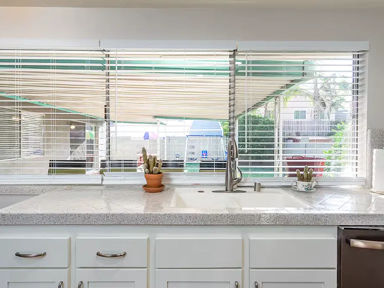 The kitchen with the view of the backyard and coverd patio. The blinds can be raised or closed
