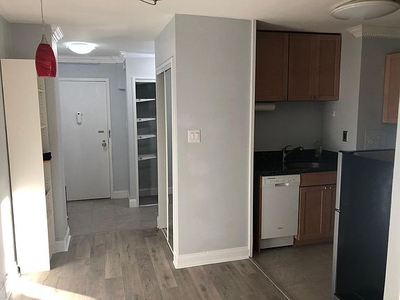 View of front door and kitchen from main living area.