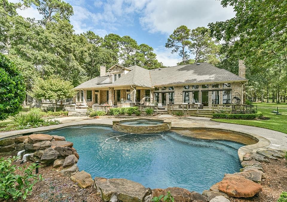 Exterior rear view of this beautiful oasis on 1.795 acres. This home is located in a private cul-de-sac in the gated subdivision of Lakewood on Lake Conroe. There are 3/4 bedrooms and 3.5 baths.