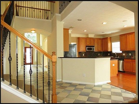 Another look at the entry showing the staircase with wrought iron spindles.