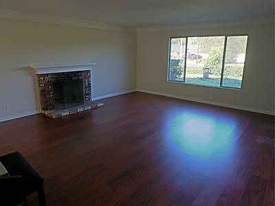 Living room enjoys views of the neighborhood, and this sweet brick fireplace