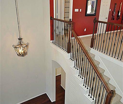 Foyer with dramatic high ceilings showcasing custom wrought iron railing