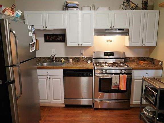 Updated kitchen has wall removed for a more open concept.  Newer stainless appliances, updated cabinetry and hardwood floors.  Door to the left leads into a screen porch and utility room with washer/dryer