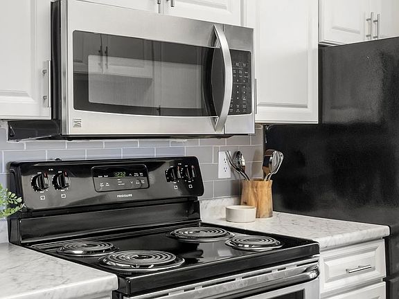 Luxurious stainless-steel appliances paired with stunning subway tile backsplash in every remodeled kitchen.