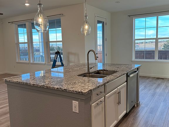 Open concept kitchen, living room and dining room looking out to back yard and view