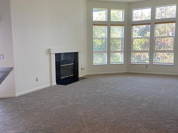 Large living room with high ceilings and extra windows and wood burning fireplace.